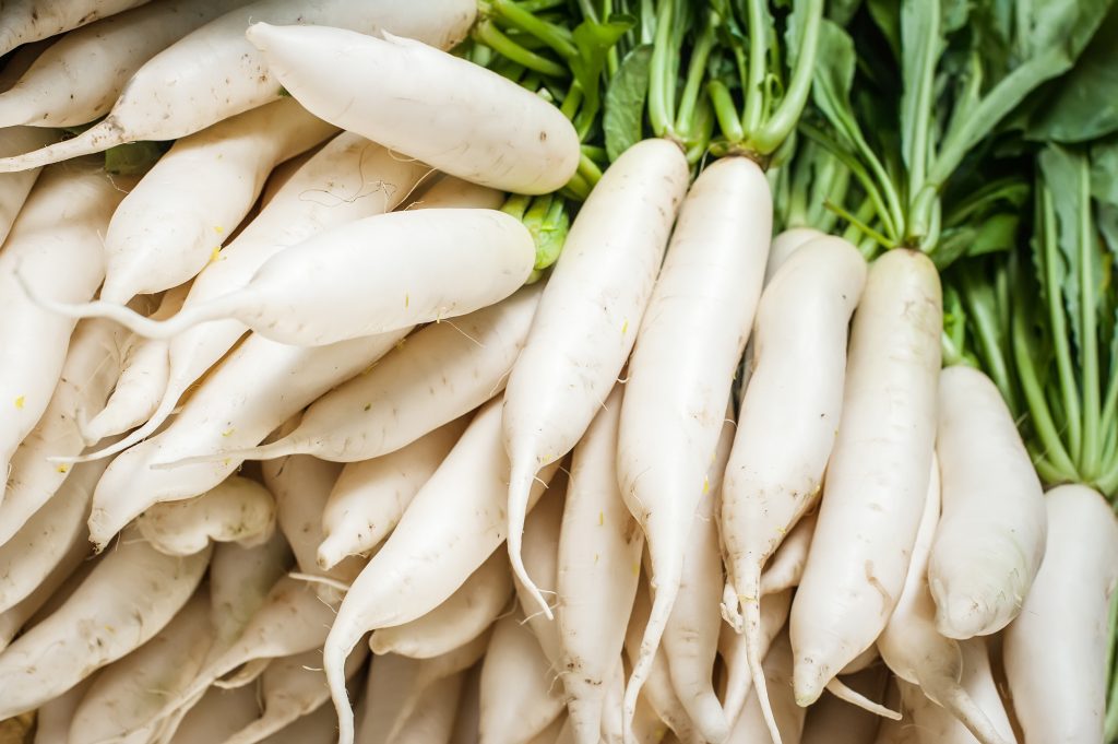 Organic local daikon radish vegetables for sale at outdoor asian marketplace